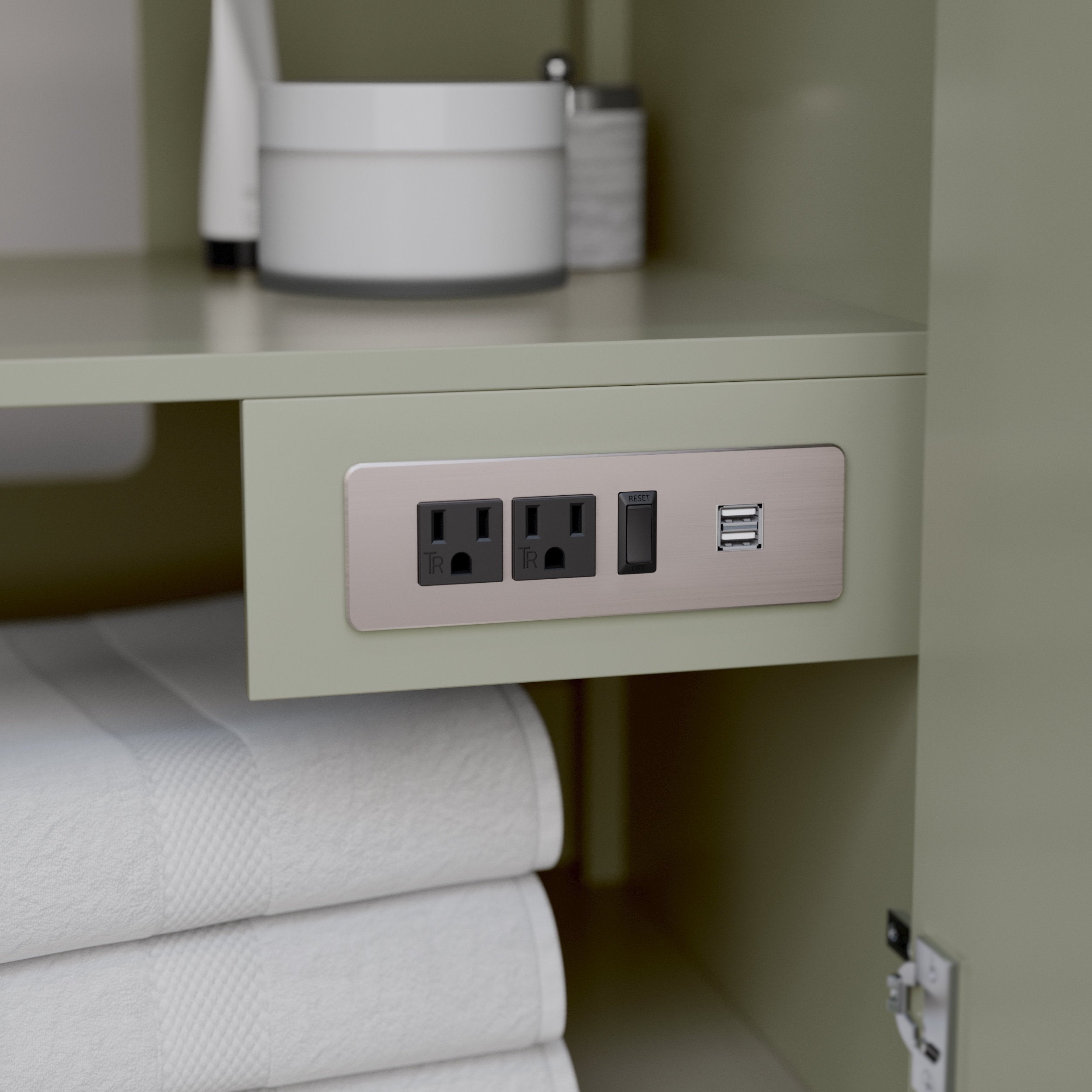 Close-up of a stone-colored wooden vanity interior shelf featuring a brushed-metal power plate with two grounded outlets, reset switch and dual USB ports, above neatly folded white bath towels.
