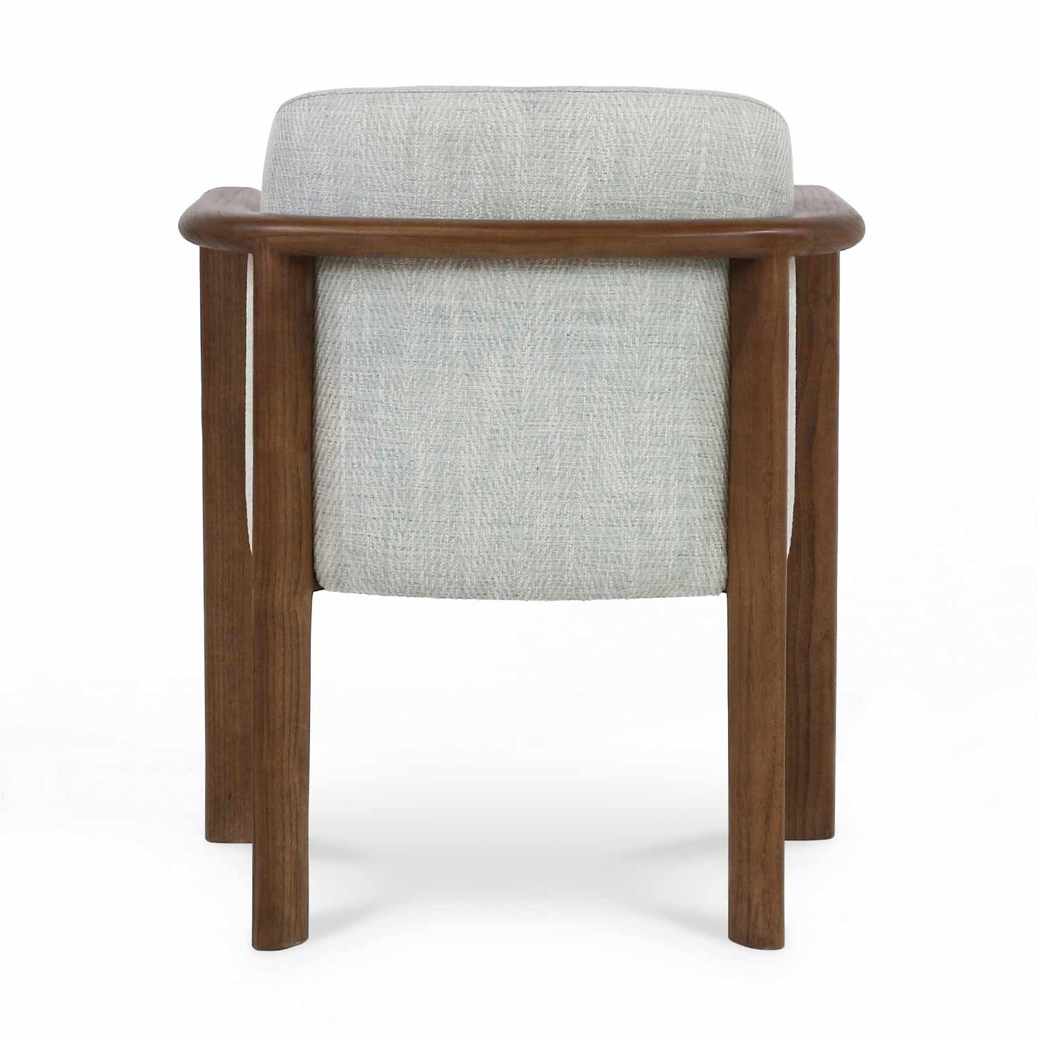 Rear view of a modern dining chair with light herringbone-patterned fabric upholstery and a rounded oak wood frame and legs.
