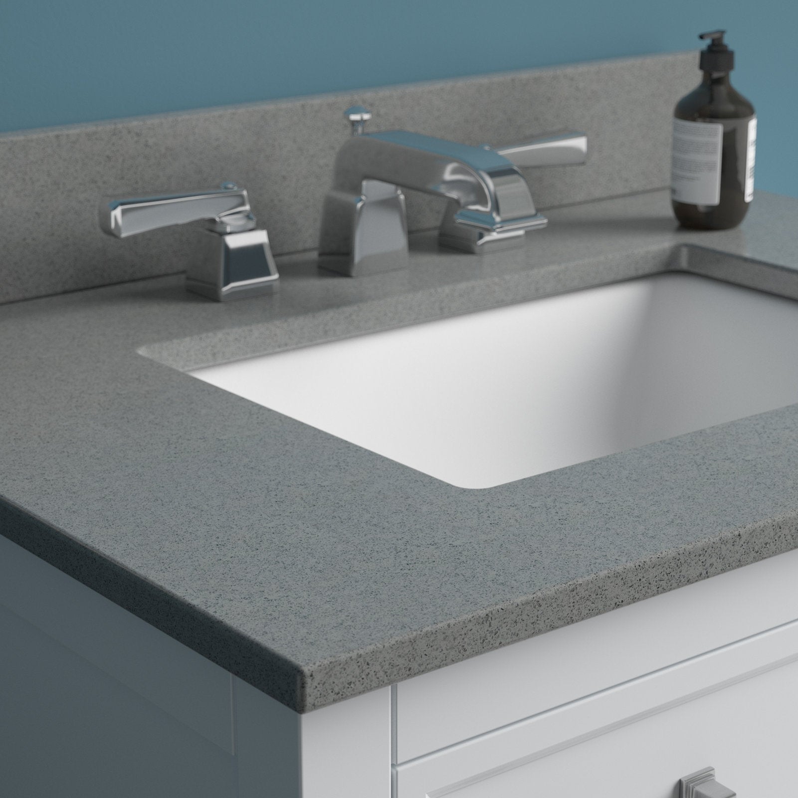 Stone-colored countertop with rectangular undermount white sink on a white solid wood bathroom vanity, shown with a chrome widespread faucet and a dark soap dispenser on the rear corner.
