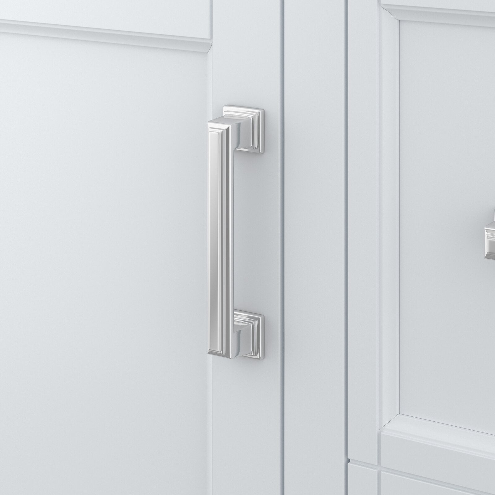 Close-up of a polished chrome rectangular cabinet pull mounted on a white paneled bathroom vanity door, showing squared mounting plates and decorative stepped-edge detailing.