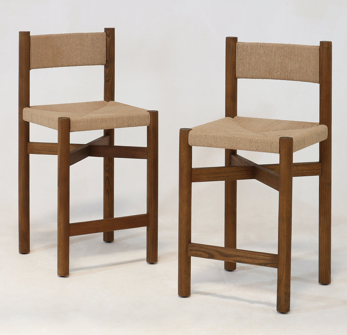 Two walnut-finish oak counter stools with natural papercord woven seats and backs, straight square legs and cross stretchers, photographed on a white background.