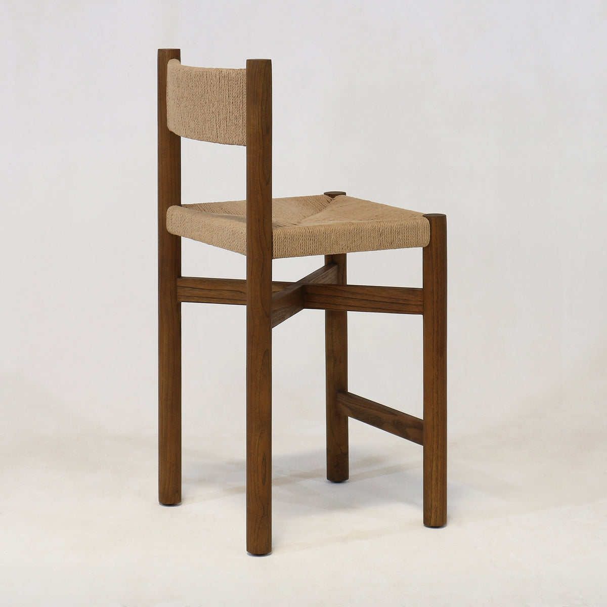 Solid walnut wood counter stool with natural papercord woven seat and short woven backrest, modern coastal style, shown against a plain white background.