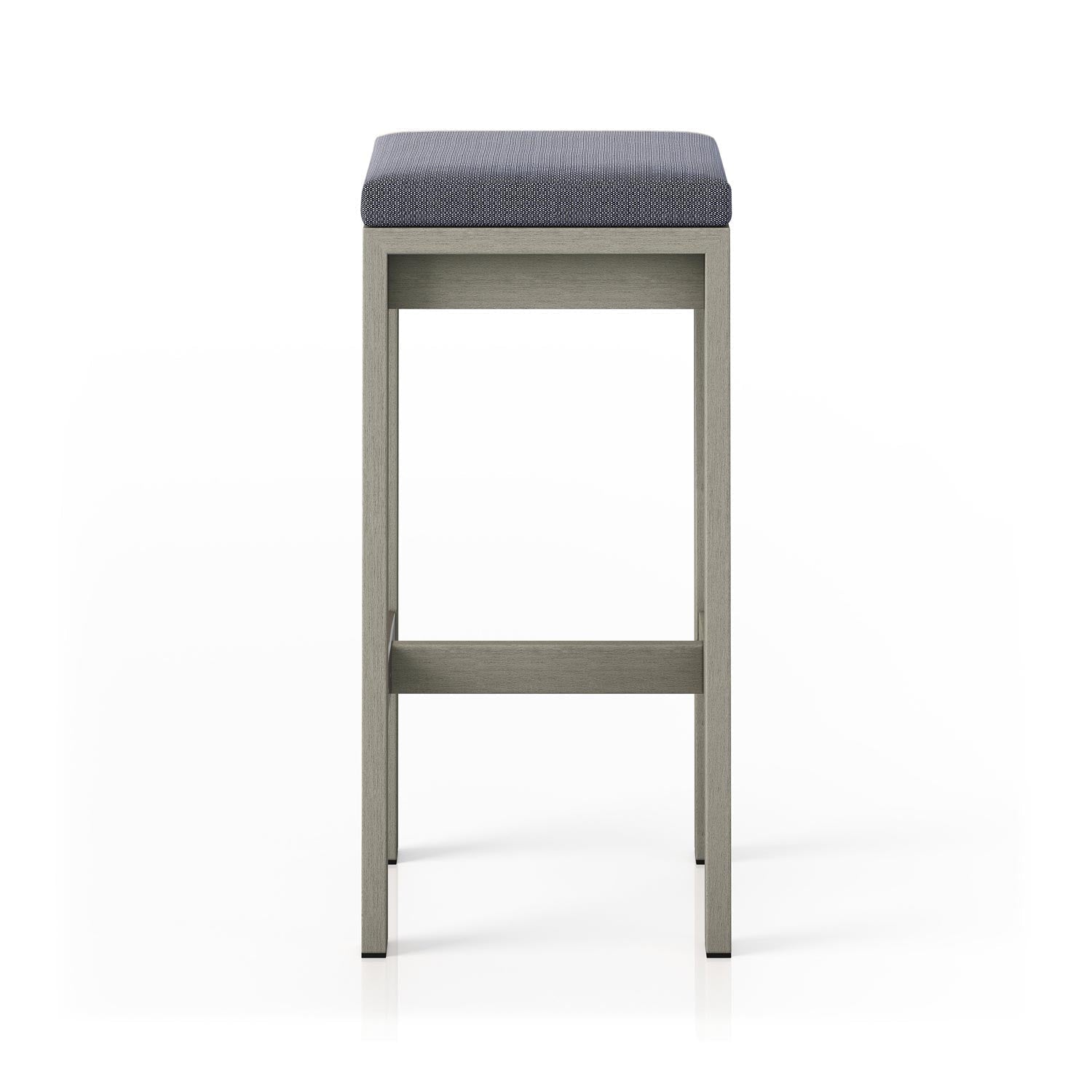 Front-facing backless outdoor bar stool with a light teak solid wood frame and a charcoal textured upholstered cushion, featuring straight legs and a horizontal footrest in a contemporary coastal style.