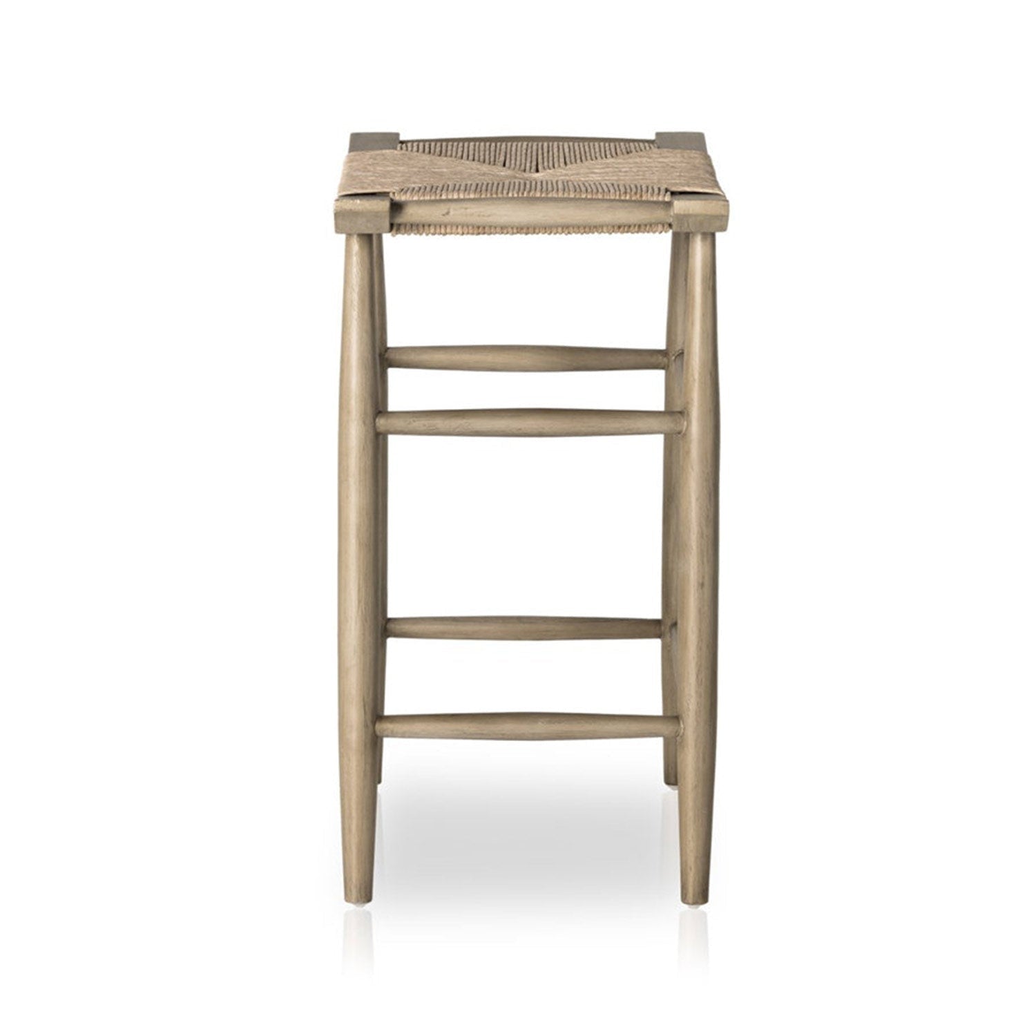 Front view of a backless outdoor bar stool in natural teak with a woven seat, tapered legs and three horizontal stretchers, shown in a coastal Scandinavian style.
