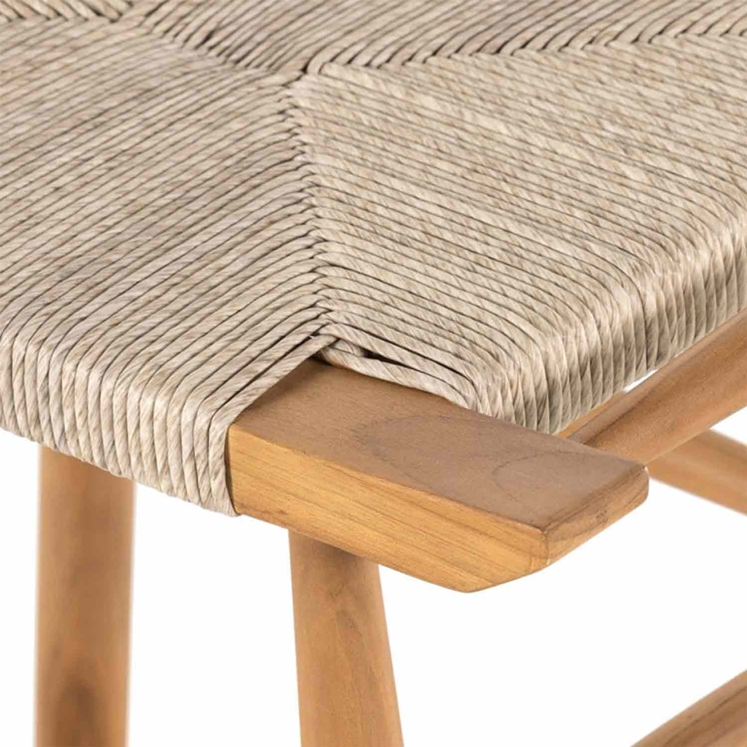 Close-up of a backless outdoor bar stool seat showing natural woven fiber cord in a diagonal pattern wrapped over a teak wood frame with a light natural teak finish.