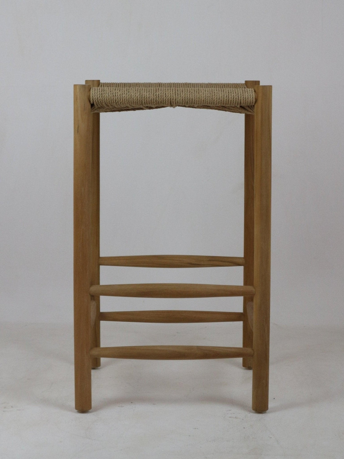 Front view of a natural solid wood backless bar stool with a woven rope seat, rounded legs and three horizontal stretchers in a minimalist modern style.