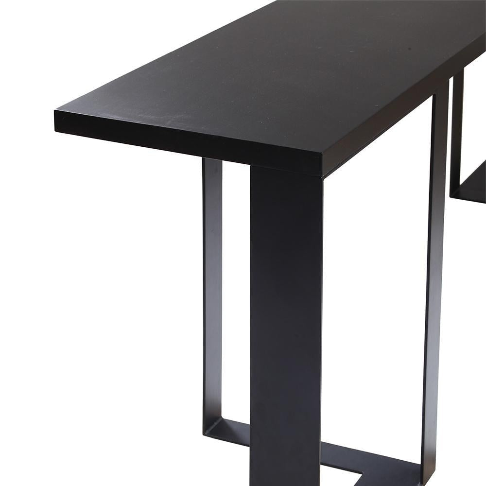 Close-up of a modern mahogany-black console showing the flat wood tabletop edge and rectangular steel beam leg with a matte black finish.