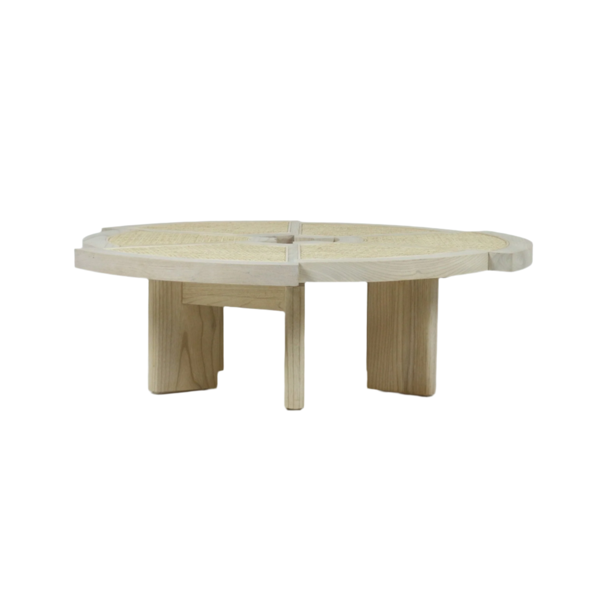 Low round coffee table in natural blonde wood with woven cane top divided into four quadrants, thick rim and chunky minimalist legs in a modern midcentury style.
